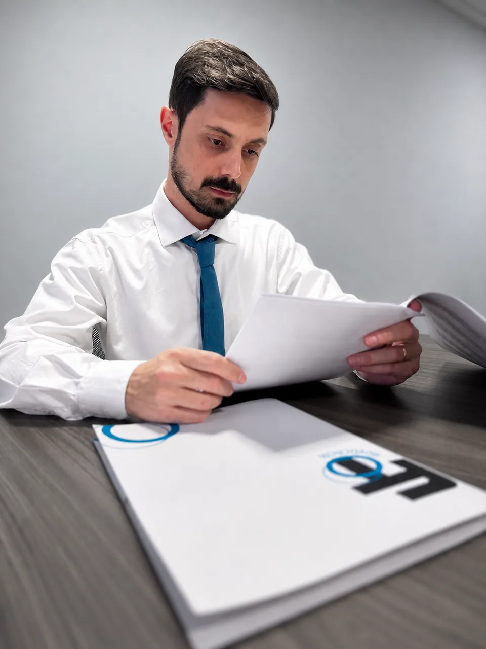 Felipe Tymotheo lendo um documento na mesa da FT Advocacia